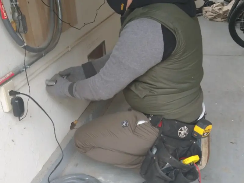 Electrician performing outlet wiring in a Jamestown garage